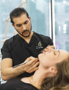 Dr. Anil Shah facial plastic surgeon in Chicago, Illinois, measuring a patient during a consultation